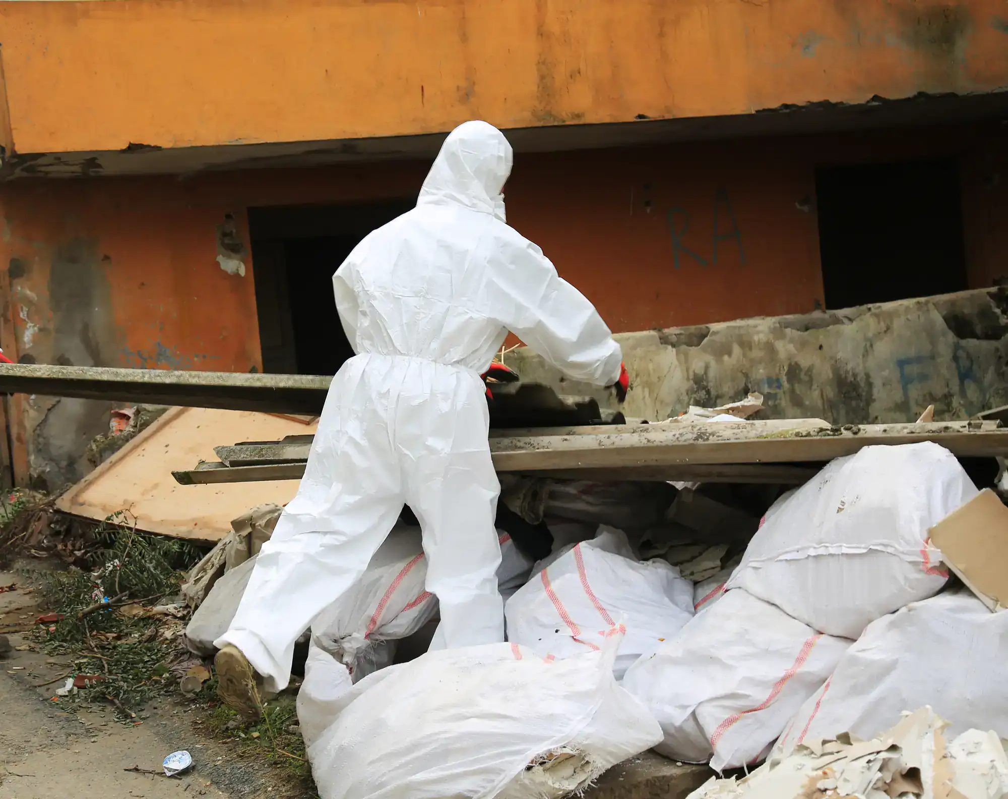 Workers wearing full asbestos removal safety gear in Montgomery County, Pennsylvania, including respirators, protective suits, gloves, and sealed containment equipment
