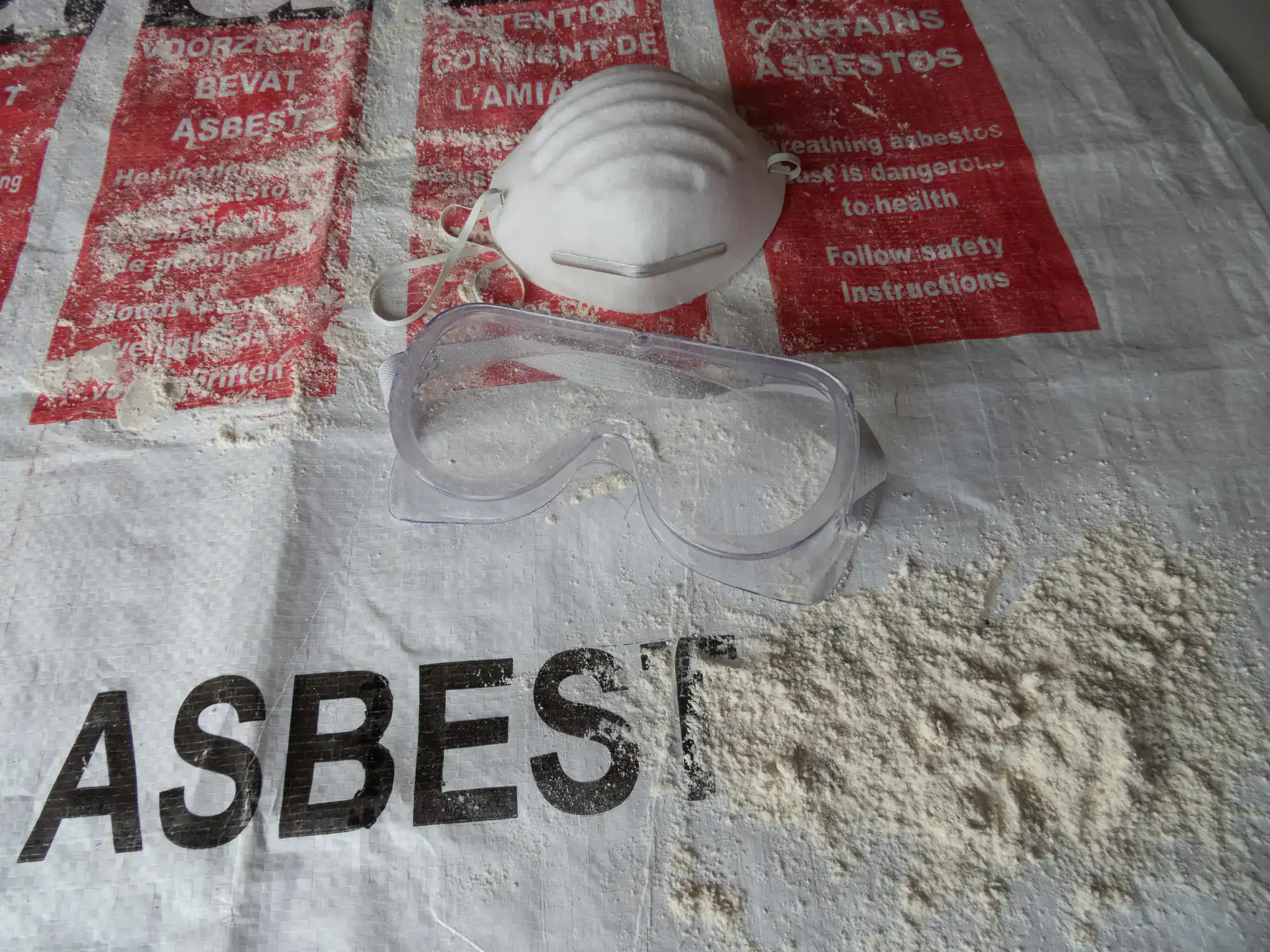 Worker wearing full asbestos safety equipment in Montgomery County, Pennsylvania, including respirator, protective suit, gloves, and sealed eye protection